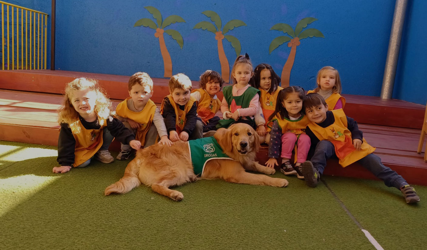 Grupo de niños junto al perro de apoyo en el patio del jardín